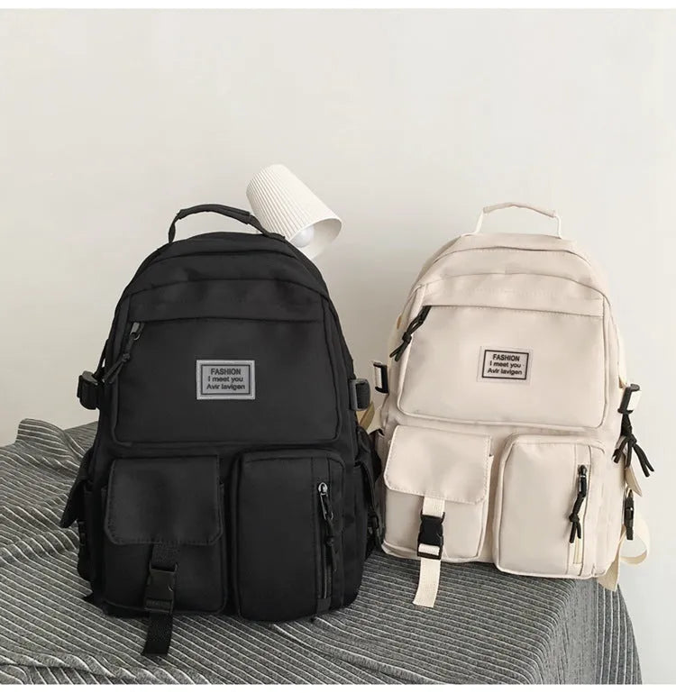 Black and white nylon student backpack with front pockets and laptop compartment.
