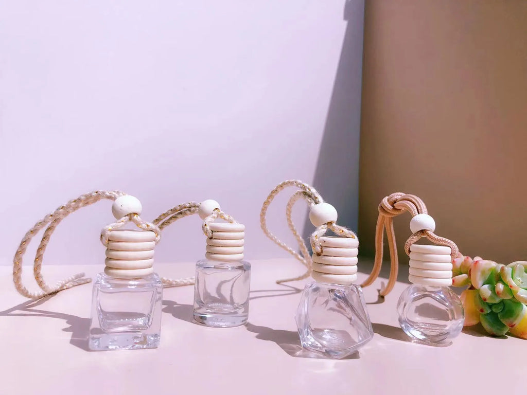 Glass car perfume pendant air freshener in cylinder, diamond, flat drum, and square shapes.