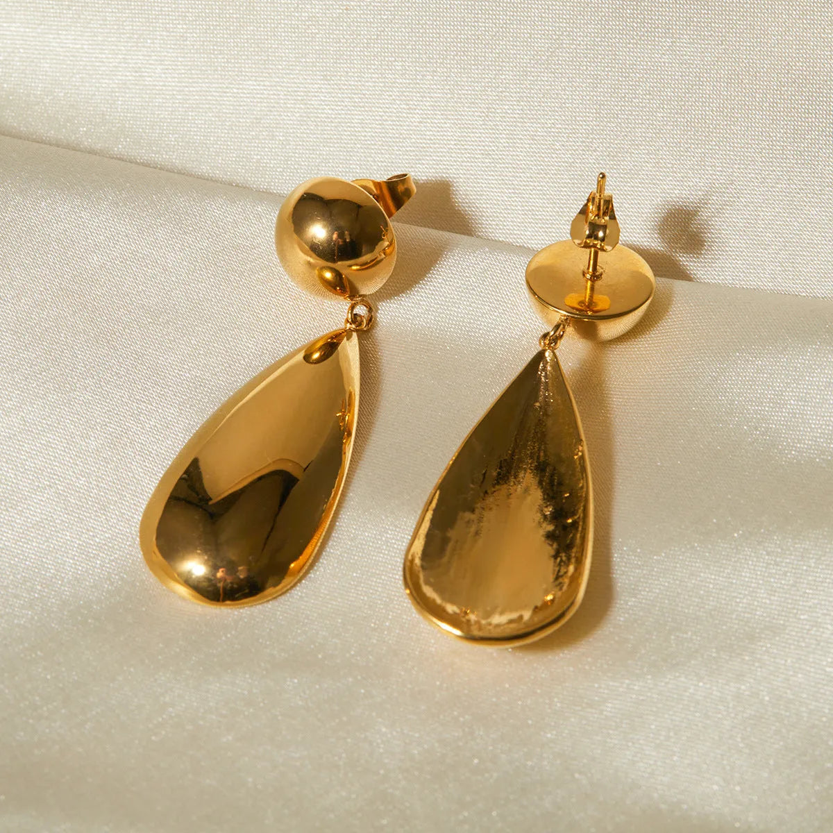 Gold electroplated stainless steel water droplet earrings with geometric hemisphere pendant design