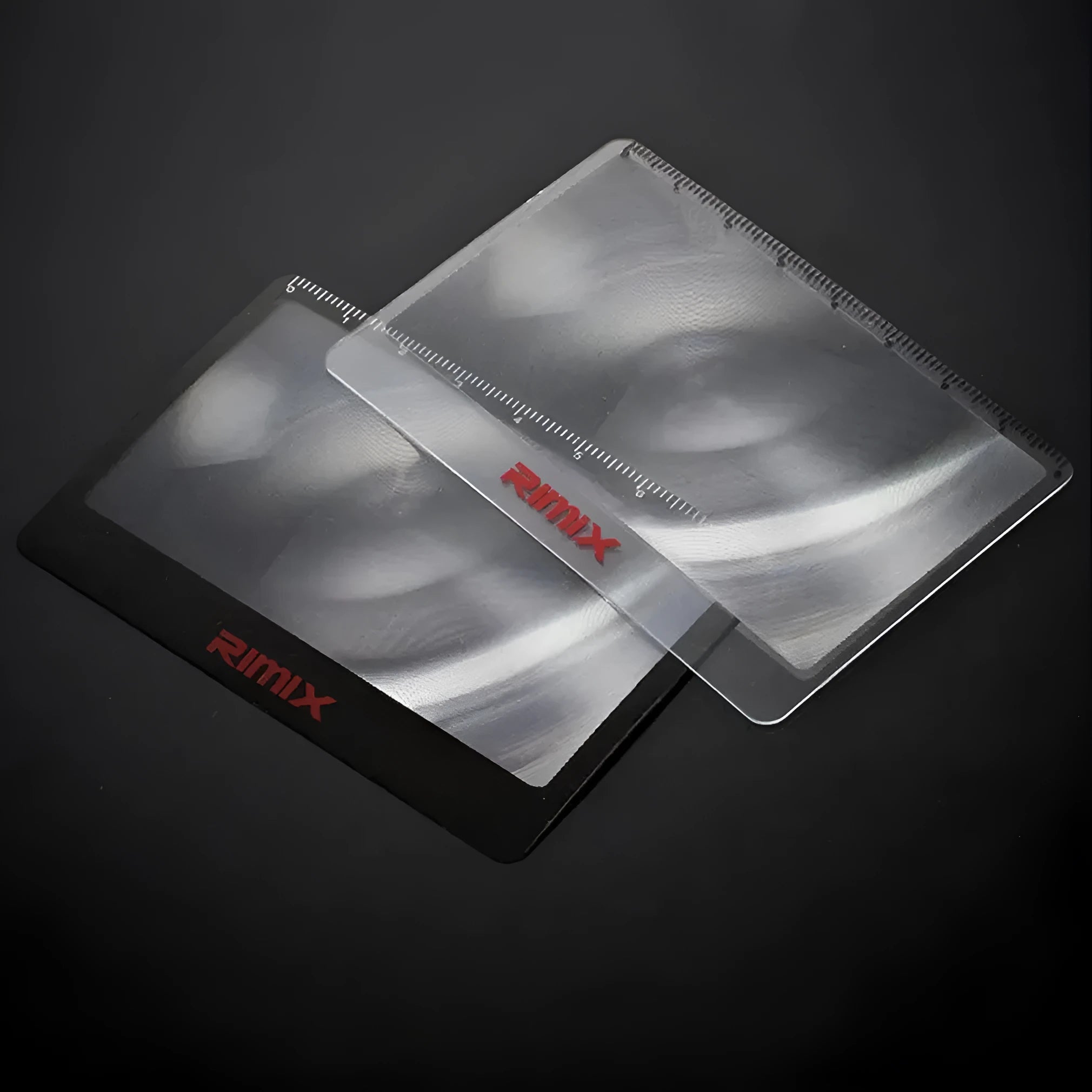 A thin, credit-card sized black plastic magnifier with a Fresnel lens, shown next to a bank card for scale.