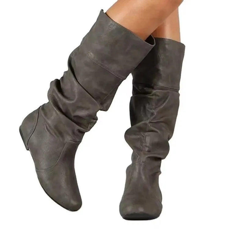 Women's black slip-on flat boots with round toe and high cylinder shaft on neutral background