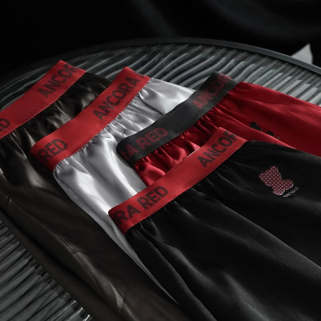 Men's solid colour polyester boxer briefs in black, shown flat, with mid waist design.