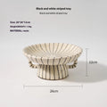 Black and white striped synthetic resin fruit plate on a wooden table.