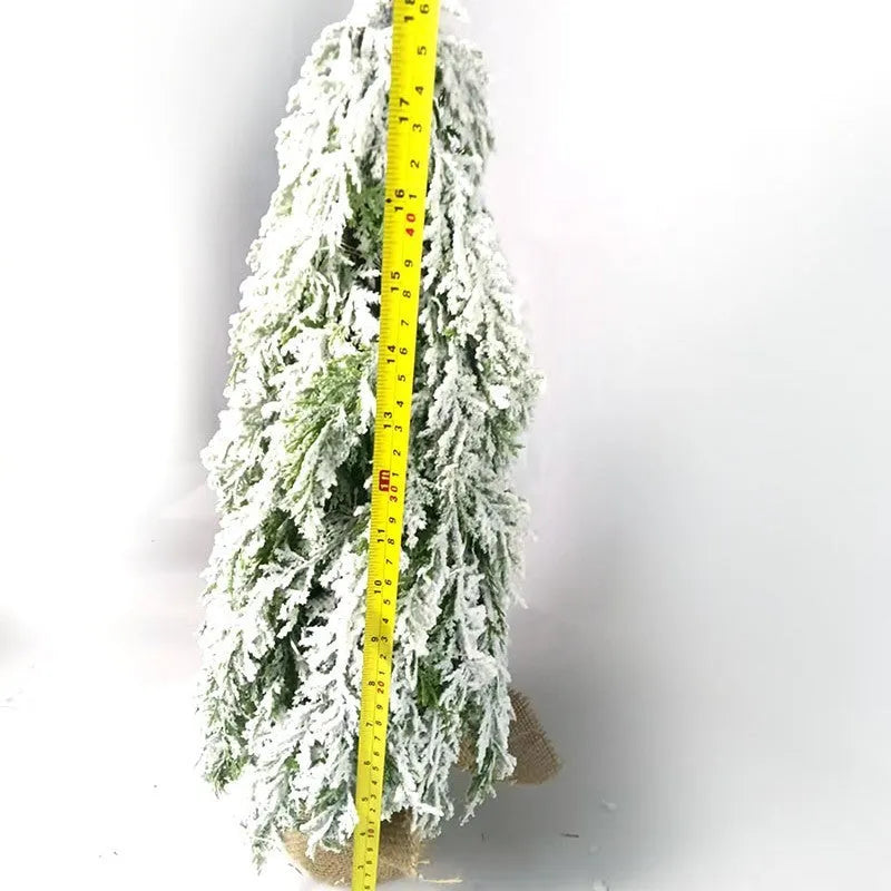 Small 24-inch white snow spray Christmas tree with integrated lights on desktop