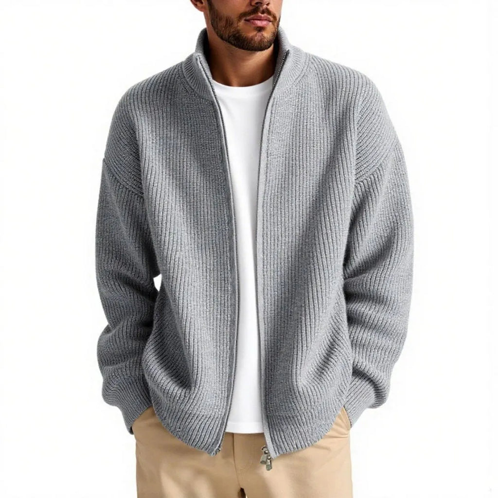 Man wearing a loose-fit grey cardigan sweater coat, showing the relaxed silhouette and knit texture.