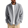 Man wearing a loose-fit grey cardigan sweater coat, showing the relaxed silhouette and knit texture.