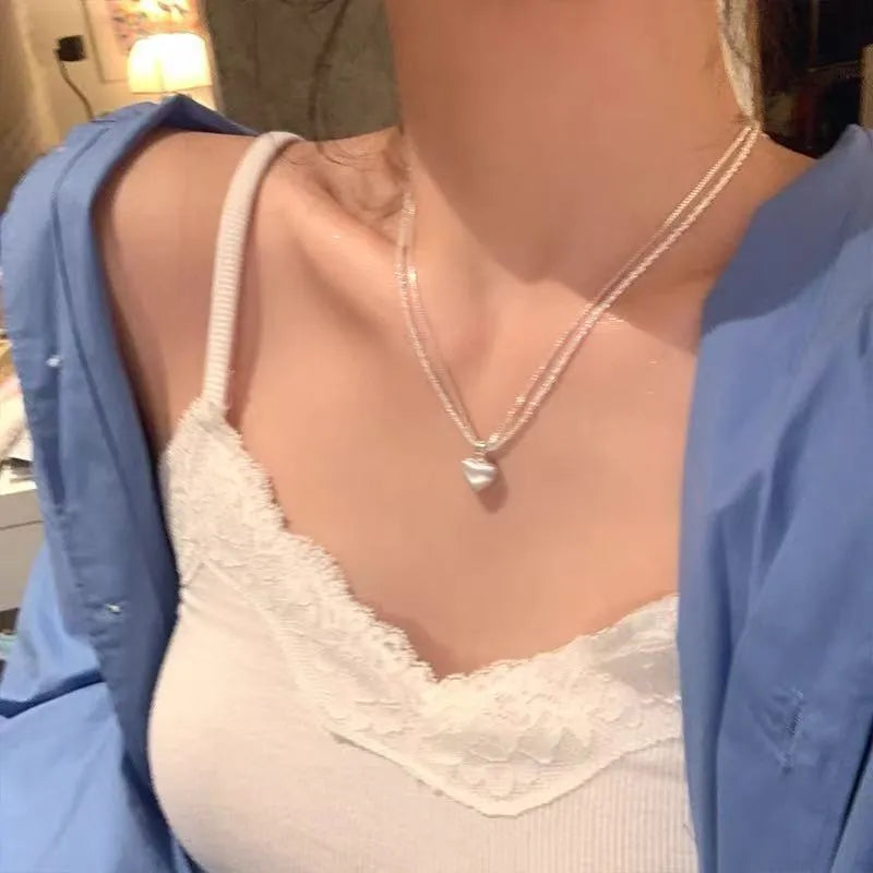 Women's double-layer brushed heart pendant necklace on a regular chain, silver tone.