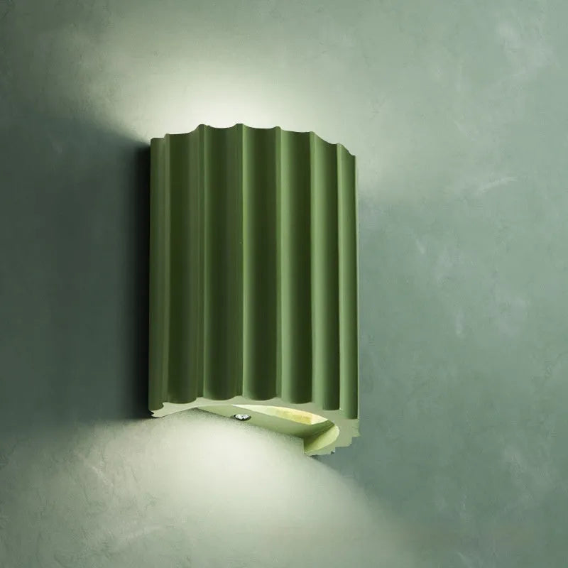 Nordic style wall light with a white macaron shell-shaped shade mounted on a hallway wall.