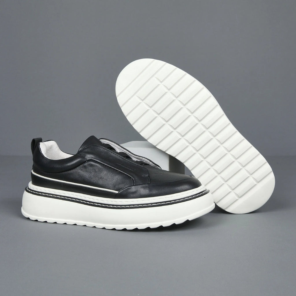 Black casual slip-on sneaker with leather upper, foam platform sole, and elastic band – side view