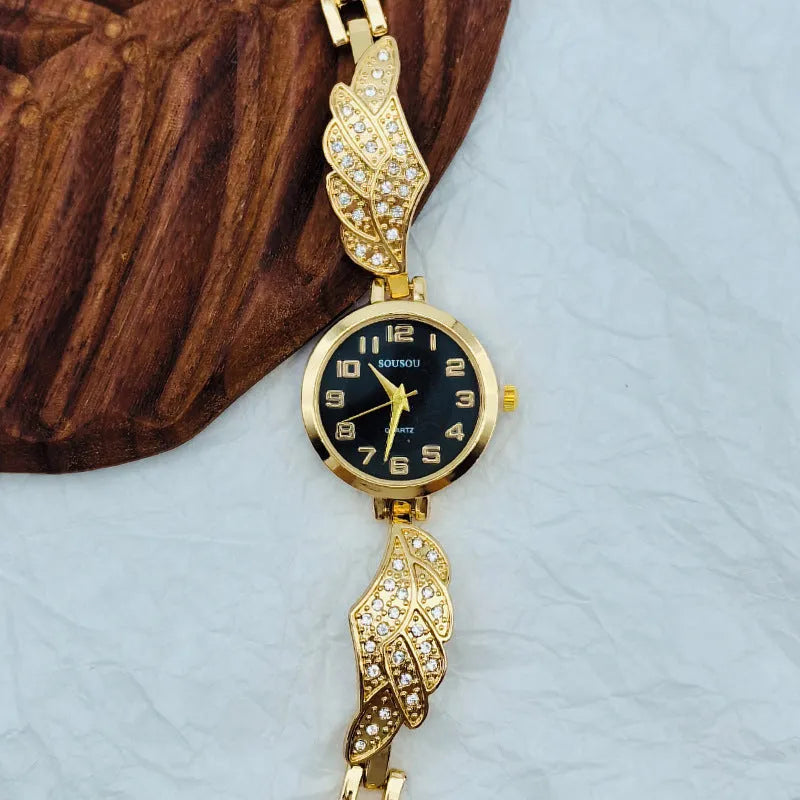 Stainless steel women's watch with round dial on wrist, showing gold colour surface and vachette clasp.