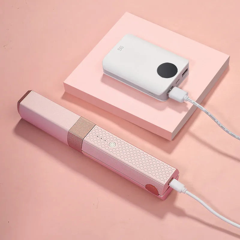 Pink cordless USB hair straightener with ceramic plates on a white background.