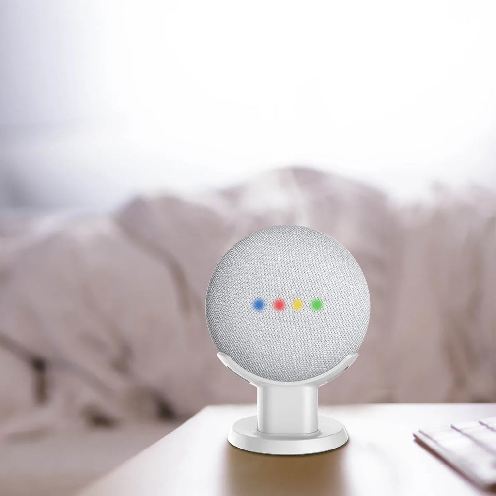 Black Google Home Mini plastic stand on a wooden desk