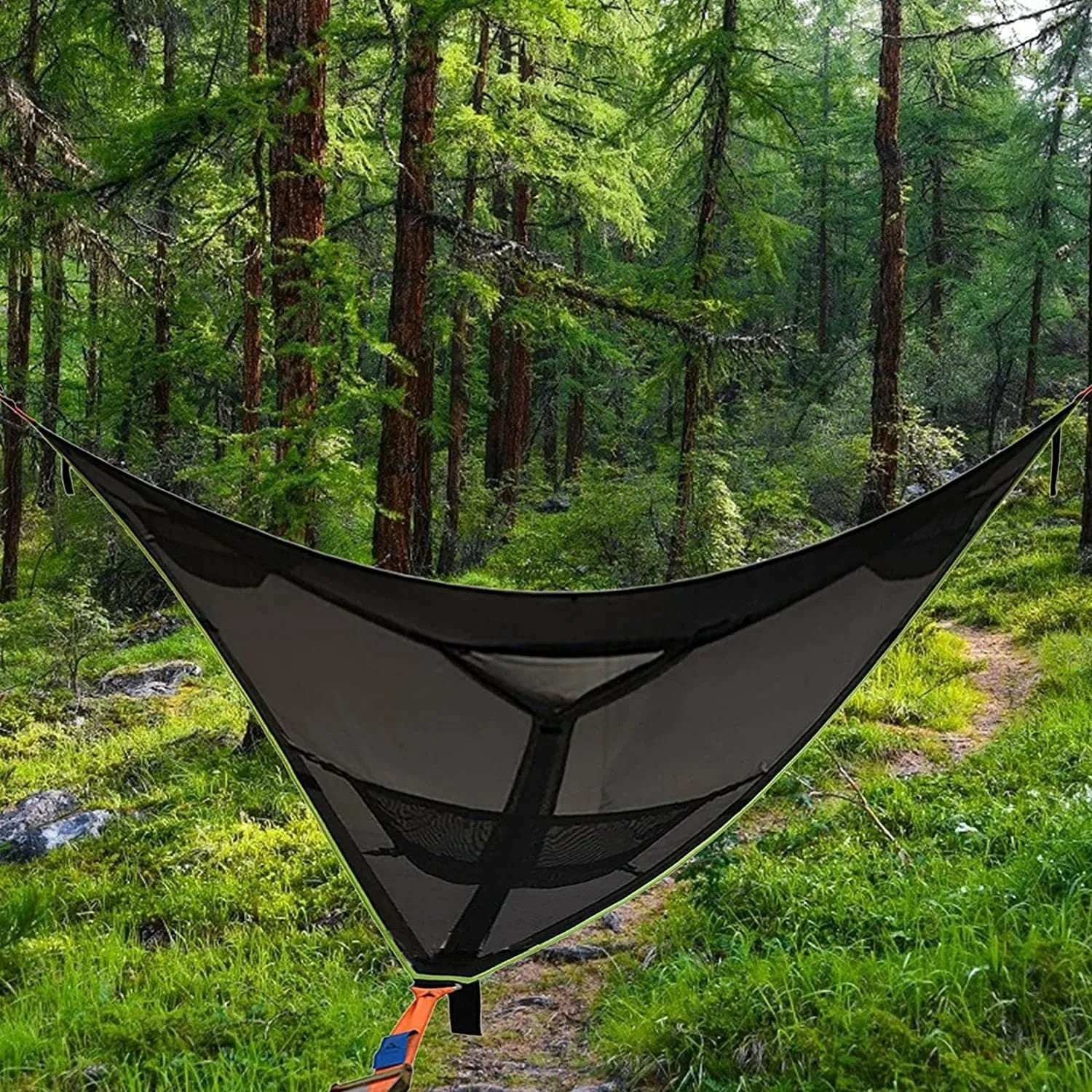 Black polyester portable multi-person triangle hammock lying on grass with trees in background