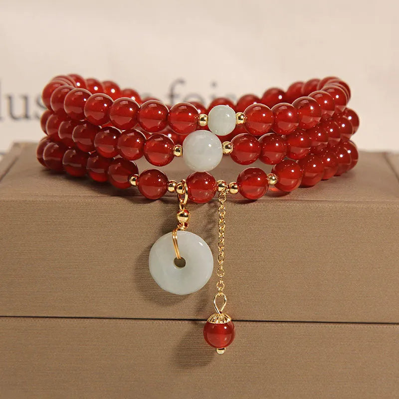 Women's multi-layer bracelet with red agate stones and crystal embellishments on adjustable band