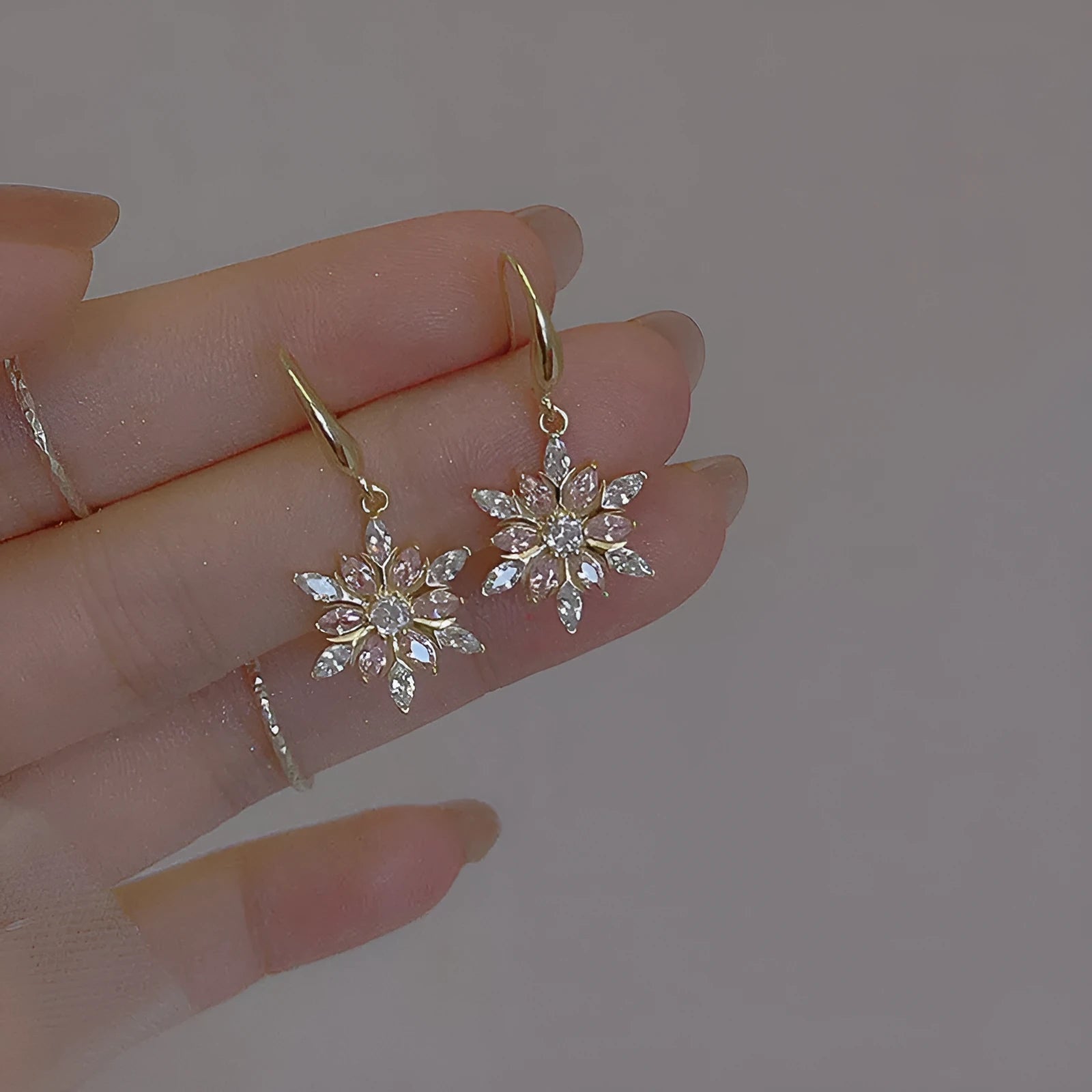 Gold snowflake earrings with zircon stones on alloy base, geometric design for women