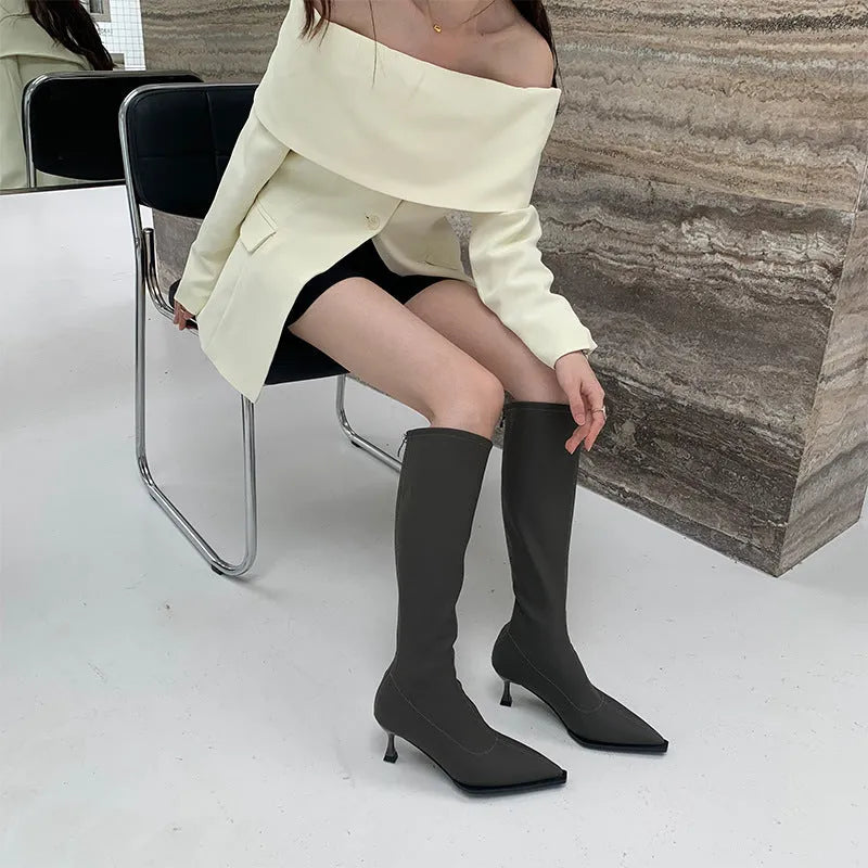 Black women's below-the-knee boots with a pointed toe, stiletto heel, and back zipper.