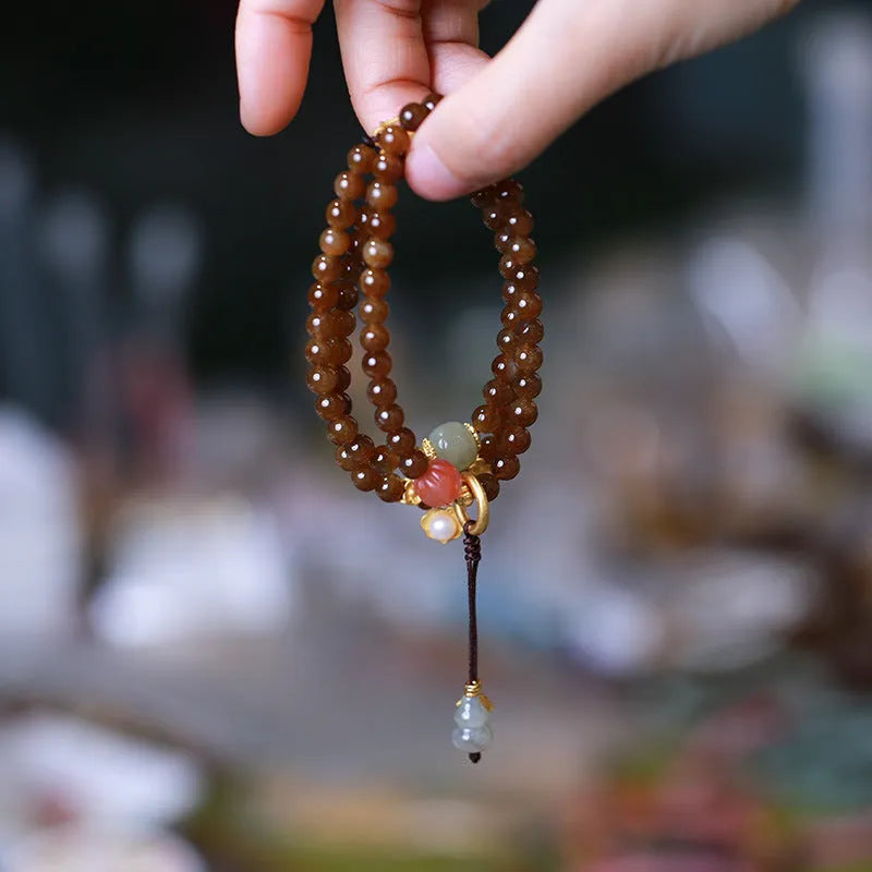 Brown Hetian jade bracelet with three-ring design featuring carved gourd and butterfly charms, silver-plated connectors