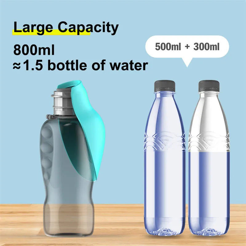 Blue-grey foldable dog water bottle with drinking trough open, showing wrist strap and lock key.
