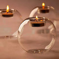 Handmade round hollow blown glass candle cup on a table.