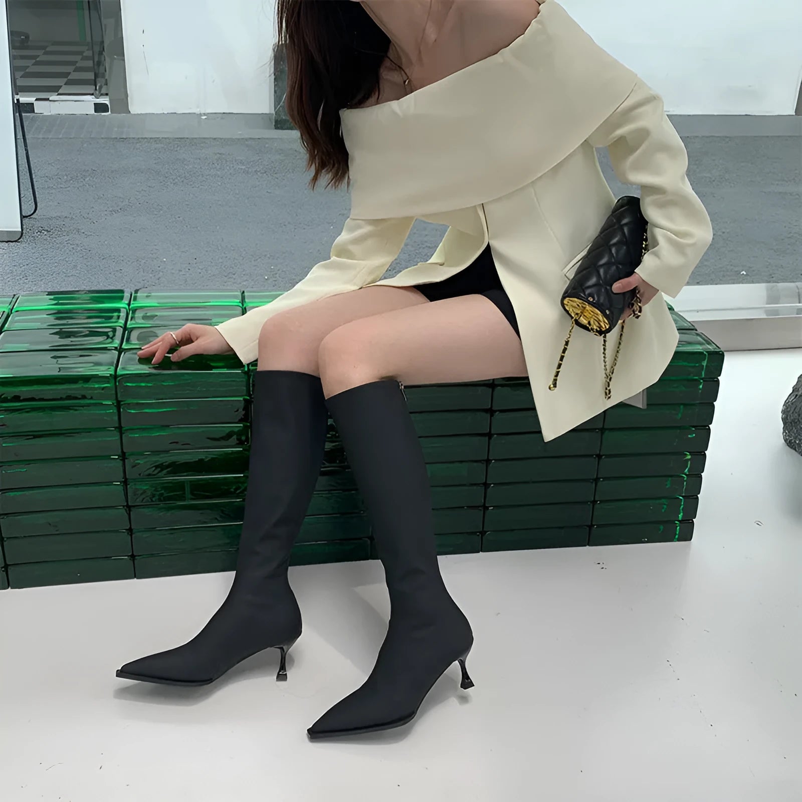 Black women's below-the-knee boots with a pointed toe, stiletto heel, and back zipper.