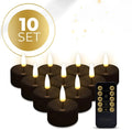 Set of four black LED tealight candles with flickering flame effect on a table.