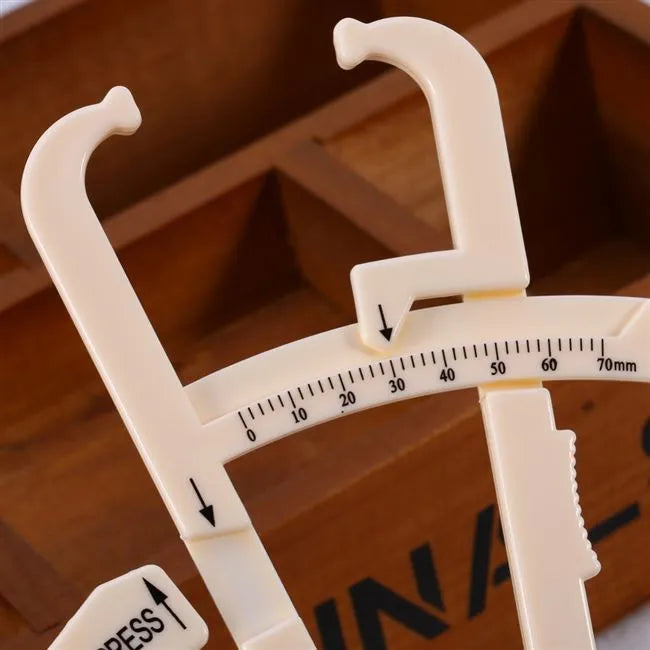 Transparent acrylic body fat caliper showing measurement scale up to 200mm