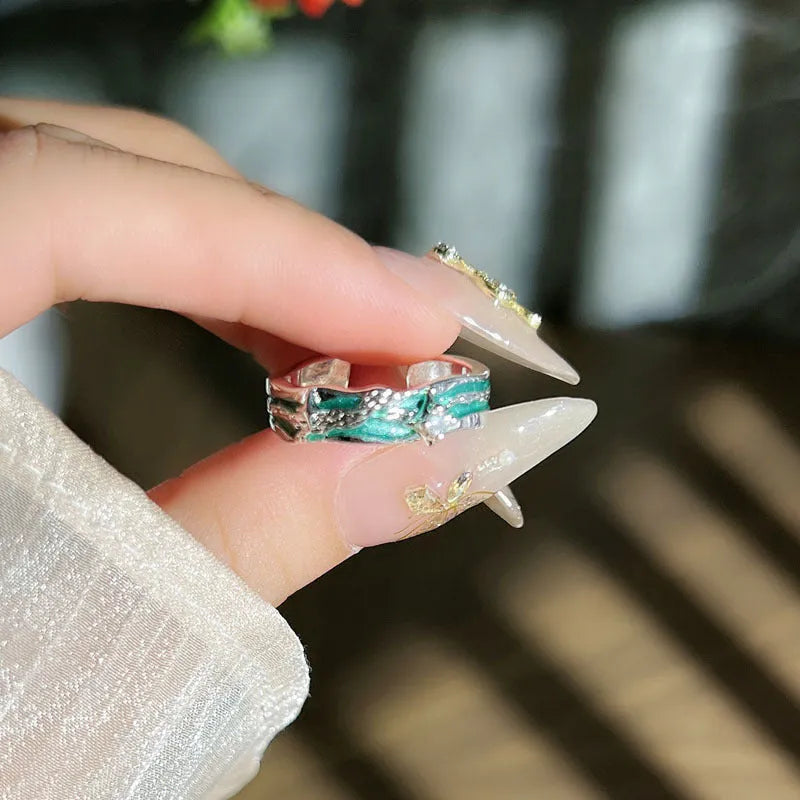Mint green enamel asterism ring with copper folding geometric design on a hand.