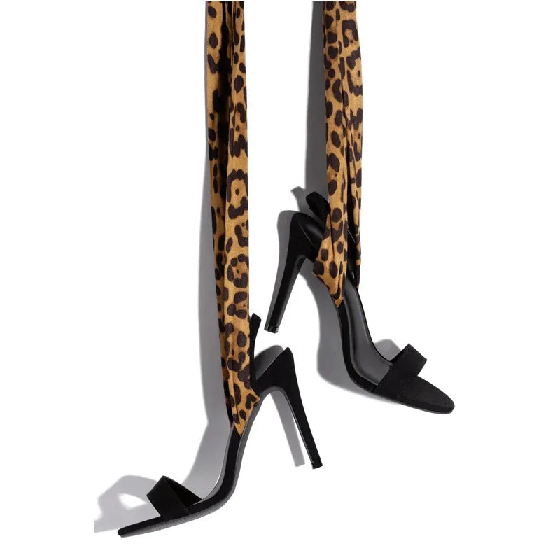 Light brown leopard print women's high heels with cross-straps and a tall stiletto heel.