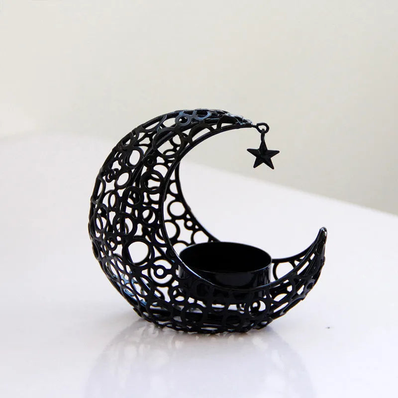 Gold crescent moon metal candle holder with hollow pattern on a wooden table