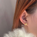 A pair of women's silver pearl stud earrings with geometric star accents on a grey background.