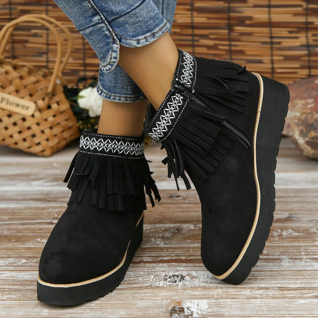 Women's dark brown suede ankle boots with wedge heel, platform sole, side zip, and tassel detail.