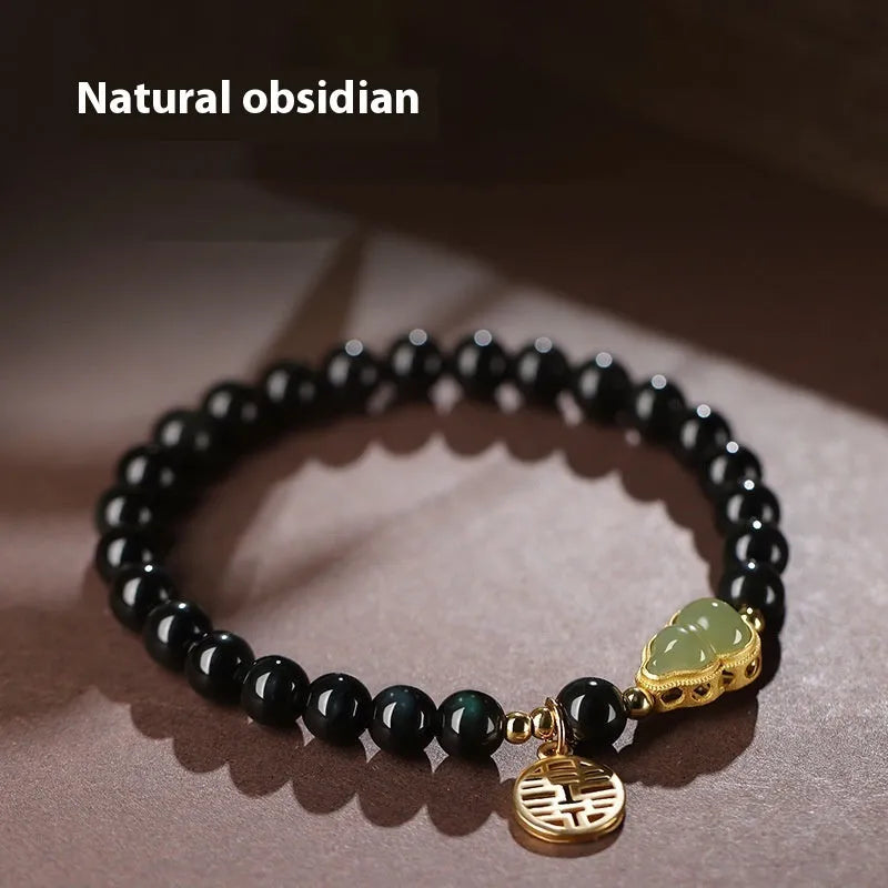 Black obsidian bracelet with a Hetian jade gourd pendant, showing geometric beads.