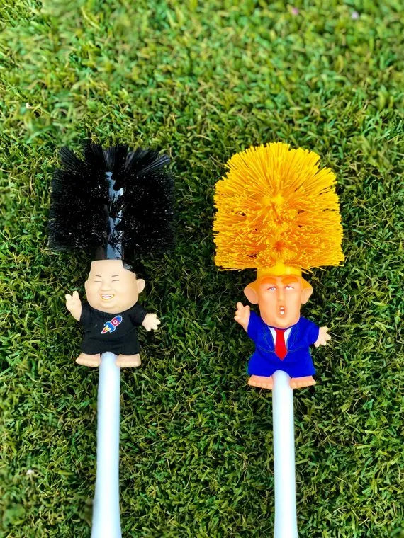 Yellow plastic Donald Trump novelty toilet brush with hanging slot.