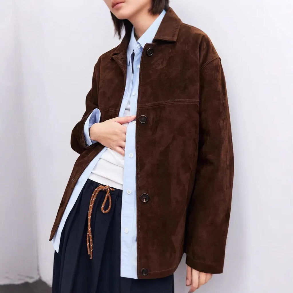 Yellow brown women's mid-length cashmere coat with Peter Pan collar and leather belt on a hanger.