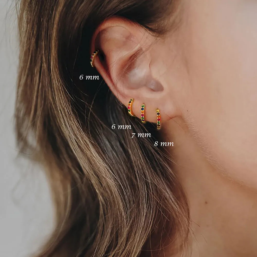 Circular perforated stud earrings in gold, rose gold, and silver colours on a copper base.