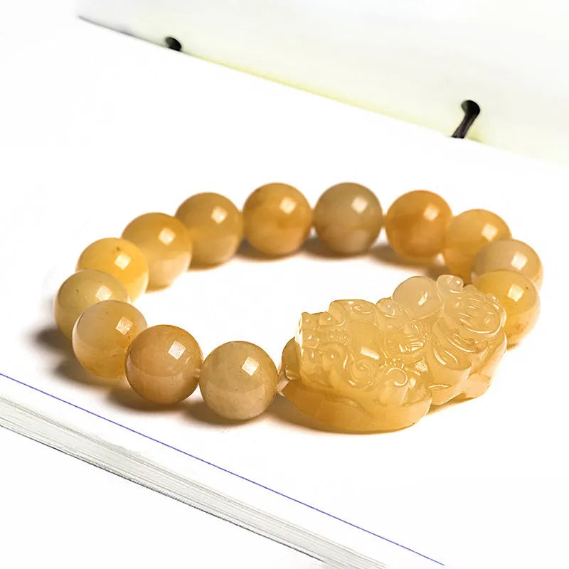 Golden thread jade bracelet with carved money motif showing detailed surface texture and jade beads