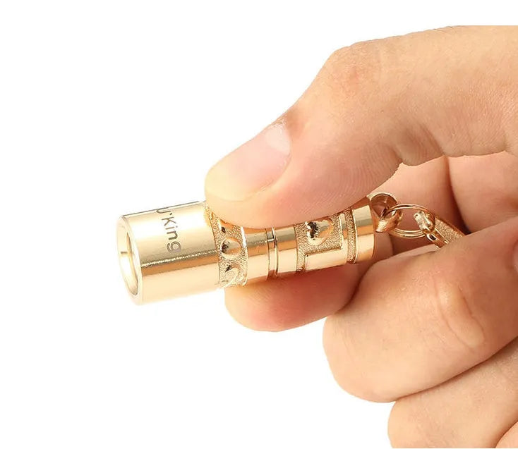 Gold zinc alloy waterproof LED keychain torch for outdoor and emergency use.