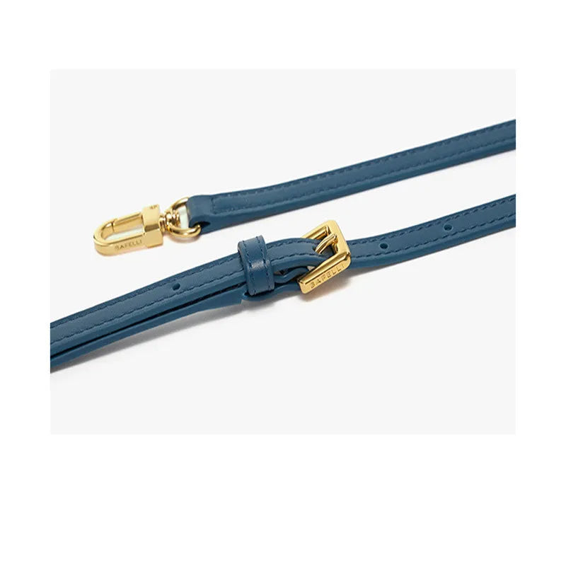 Women's wing-shaped leather tote bag with a latch buckle, shown in Atlantic blue with a cross-body strap.