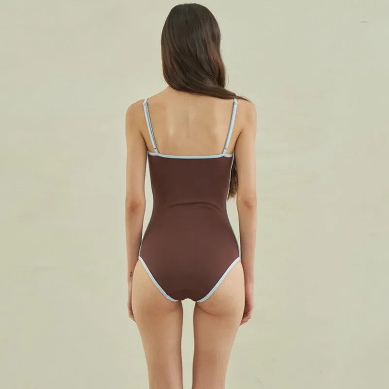 Brown women's one-piece swimsuit with triangle top design on a mannequin