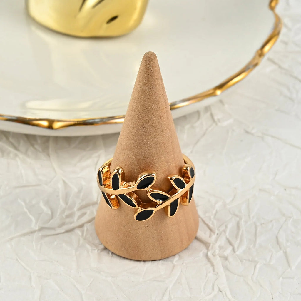 Gold geometric leaf acrylic ring for women on an index finger.