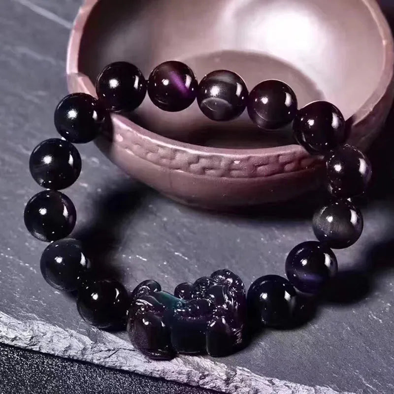 Natural ice colour eye obsidian crystal bracelet on wrist showing bead detail.