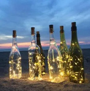Copper wire LED string lights inserted into wine bottle with warm white illumination