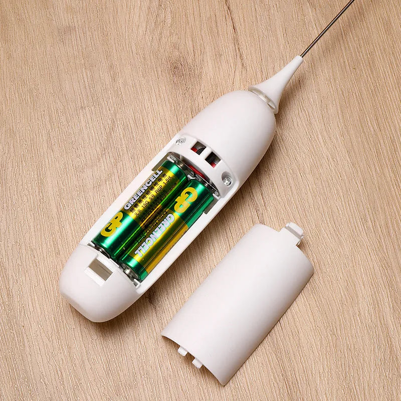 Black and white hand-held electric milk frother blender on kitchen counter