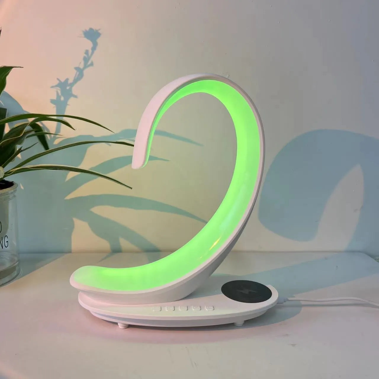 White swan-shaped desktop wireless charger with Bluetooth speaker and colourful atmosphere lighting