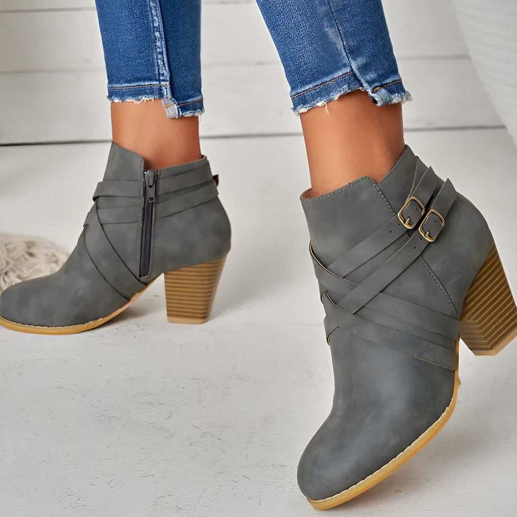 Women's grey short ankle boots with a block heel, side zipper, and buckle strap on a white background.