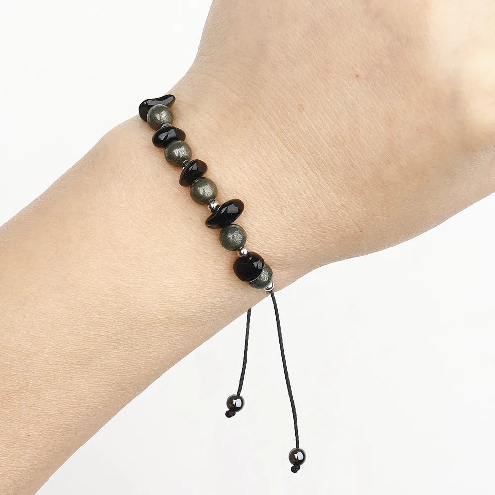 Close-up of a black garnet stone beaded bracelet with geometric design and moon charm.