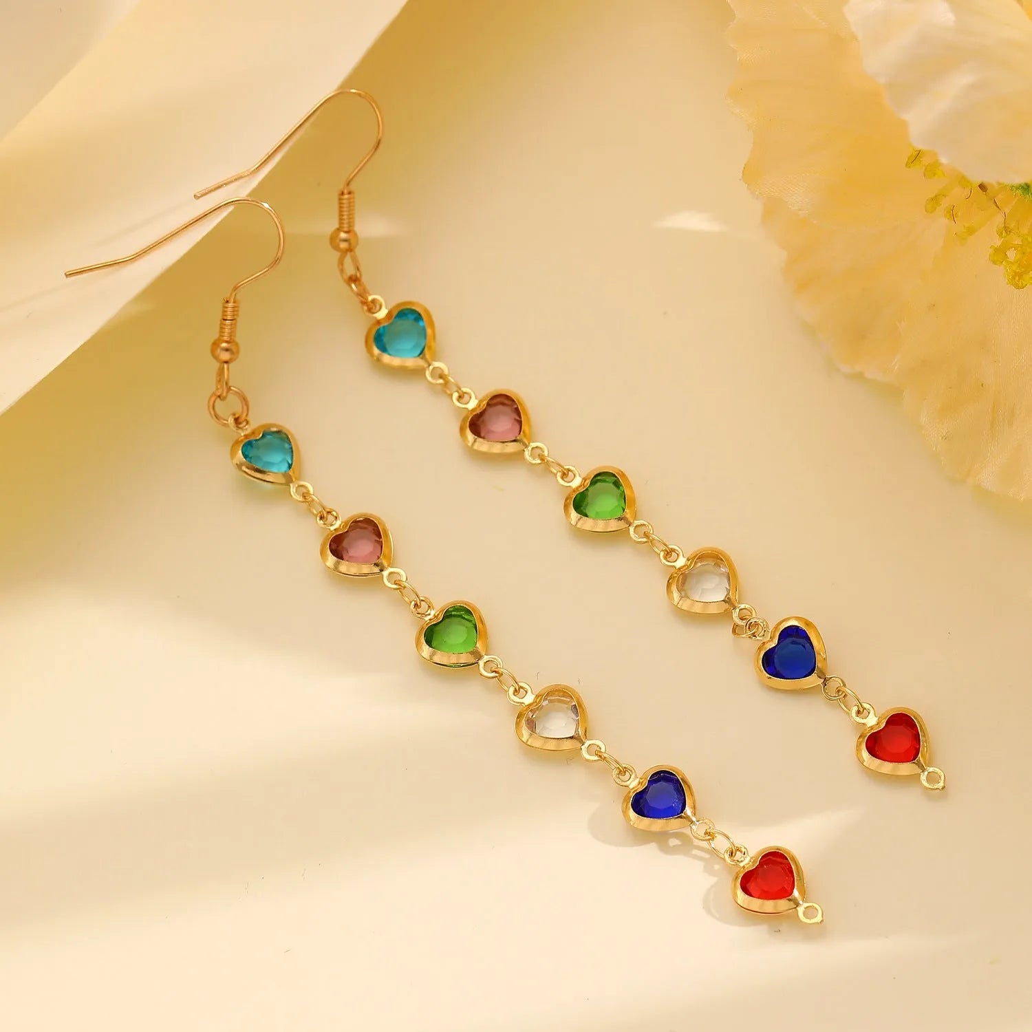 Women's colourful water drop tassel earrings in gold-tone electroplated copper on a plain background
