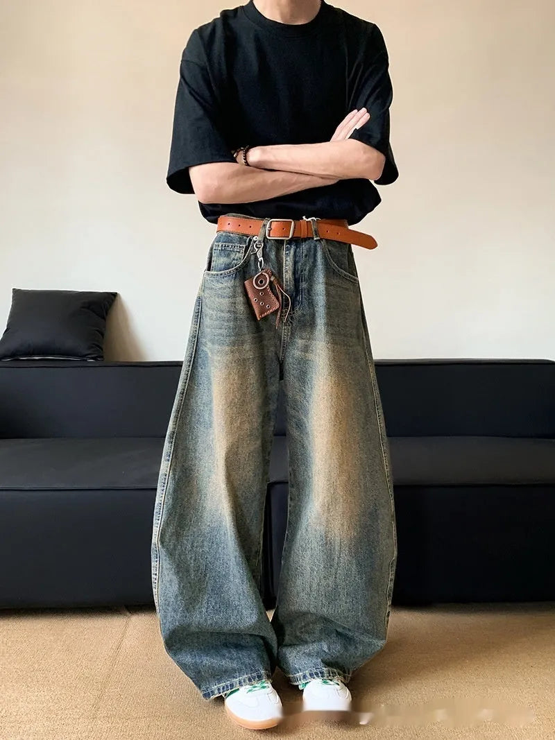 Retro blue men's distressed wide-leg jeans on a neutral background, showing machete detailing and mid-waist zip fly.
