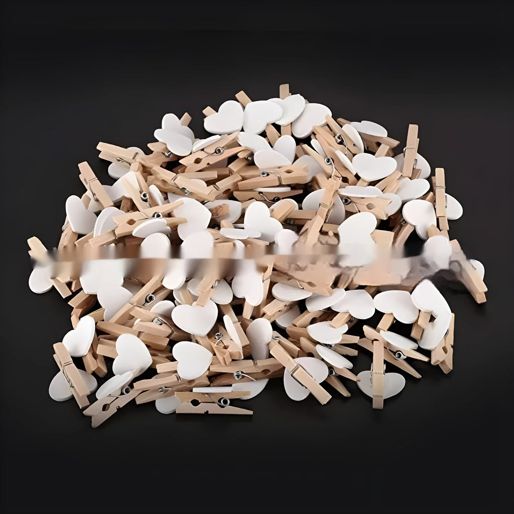 Five handmade solid wood heart-shaped hair clips in red, white, and pink on a wooden surface.
