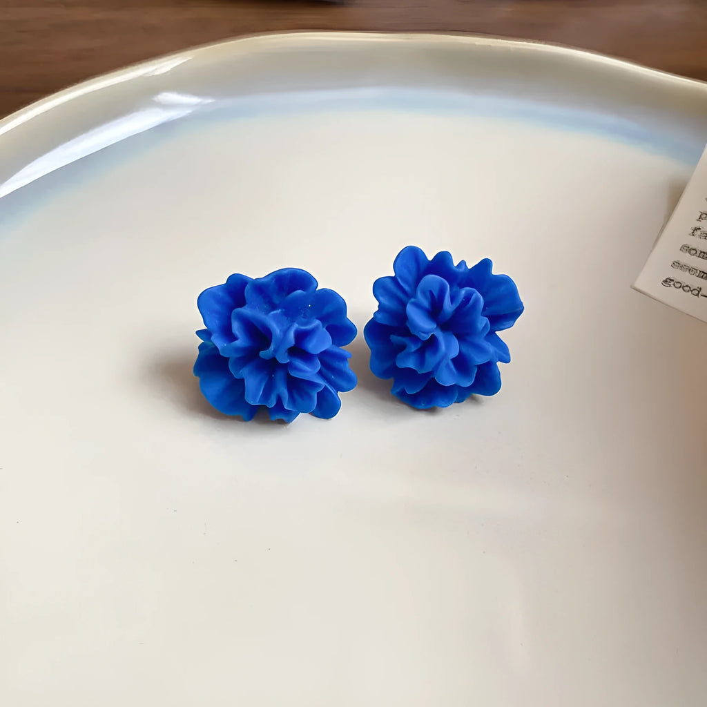 Handcrafted geometric cloth earrings with blue resin flower and silver needle detailing
